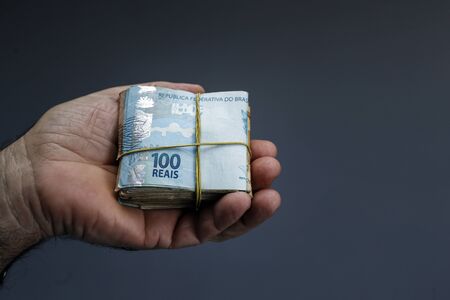 Hands holding Brazilian real notes, money from Brazil, notes of Real, Brazil BRL banknote, Brazilian...