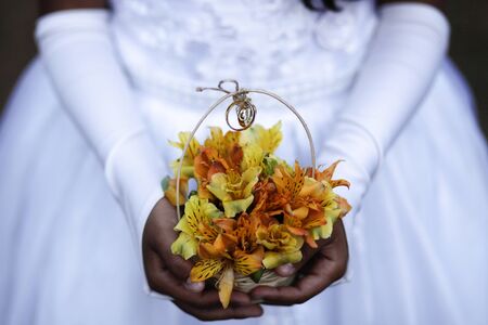 Child hands holding bouquet with wedding ringsの写真素材