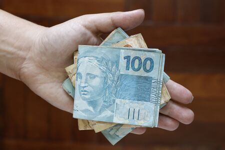 Hands holding Brazilian real notes, money from Brazil, notes of Real, Brazil BRL banknote, Brazilian currency, economy and business.の写真素材