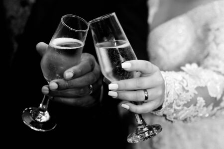 hand detail with wedding rings and champagne glasses - grooms toast - golden wedding ringsの写真素材