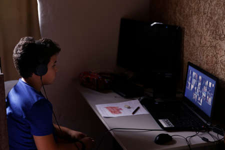 Oliveira, MG / Brazil - 2020-04-22: student participates in online classroom at home on computer