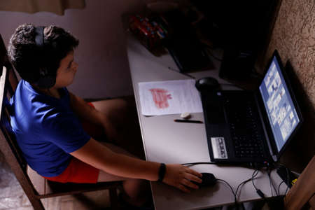 Oliveira, MG / Brazil - 2020-04-22: student participates in online classroom at home on computer