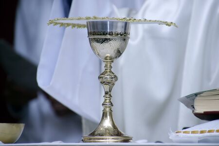 Holy Wafer. Holy communion in church. Taking holy Communion. Priest celebrate mass at the church. Cup of glass with red wine, bread. Feast of Corpus Christi.の写真素材