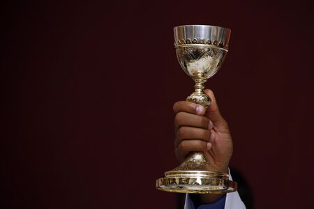 Holy Wafer. Holy communion in church. Taking holy Communion. Priest celebrate mass at the church. Cup of glass with red wine, bread. Feast of Corpus Christi.の写真素材