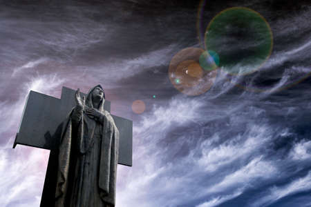 illustrative image of cemetery showing a dark marble angel and neutral skyの写真素材