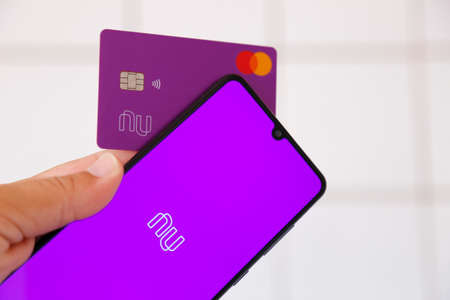 Minas Gerais, Brazil - January 25, 2021: mobile phone display and credit card with Nubank and Mastercard brand. Digital payment system.のeditorial素材