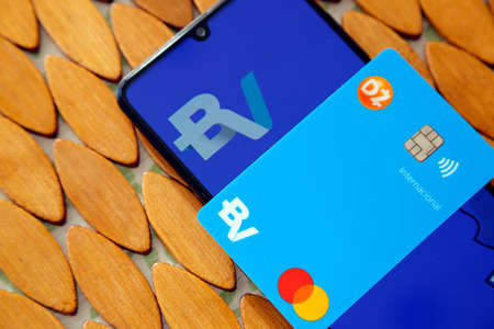 Minas Gerais, Brazil - April 19, 2021: mobile phone display and credit card with BV and Mastercard...