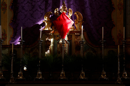 Holy Week. Cross covered with red fabric with dramatic and spot lighting. Traditional Catholic celebration Palm Sunday. Christian faith. Religious symbol.の写真素材