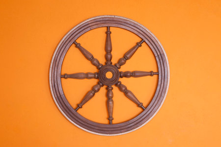 wagon wheel made from wood on an orange backgroundの写真素材