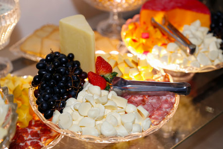 various cold foods, cheeses, snacks and salami on the trayの写真素材