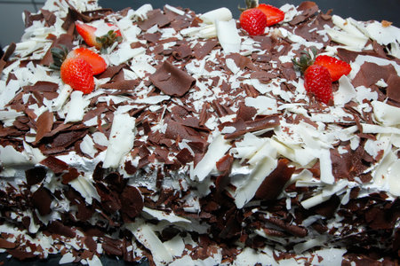 Close-up of chocolate cake with creamy frosting and fresh strawberries, perfect for sweets, bakery, and irresistible dessertsの写真素材