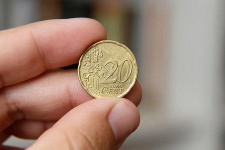 Greek twenty cent coin between fingers - euro centの写真素材
