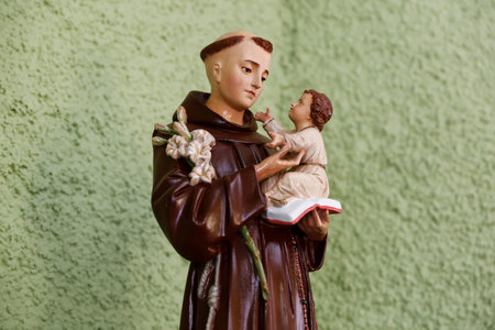 Classic statue of Saint Anthony of Padua, holding Baby Jesus and white lilies symbolizing purity. Known as matchmaker saint, perfect for devotion, weddings, and religious artの写真素材