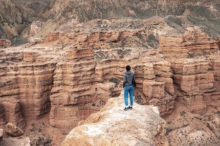 Hike in the Sinai desert. Man with backpack standing on the edge of the cliff
