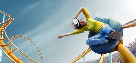 Young woman used Virtual reality helmet VR. She see Roller-coaster parkの写真素材