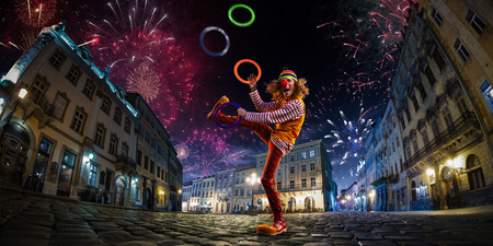 Night street circus performance whit clown, juggler. Festival city background. fireworks and Celebration atmosphere.の写真素材