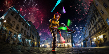 Night street circus performance whit clown, juggler. Festival city background. fireworks and Celebration atmosphere.の写真素材