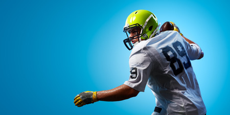 American football sportsman player on blue gradient background. Sport advertisingの写真素材
