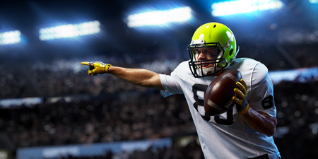 American football sportsman player on stadium in action. Sport wallpaper or advertisingの写真素材