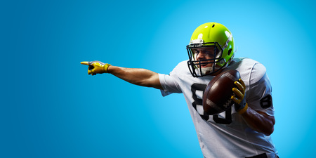 American football sportsman player on blue gradient background. Sport advertisingの写真素材
