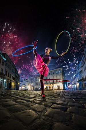 Night street circus performance whit clown, juggler. Festival city background. fireworks and Celebration atmosphere. Wide engle photoの写真素材