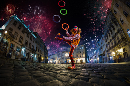 Night street circus performance whit clown, juggler. Festival city background. fireworks and Celebration atmosphere.の写真素材