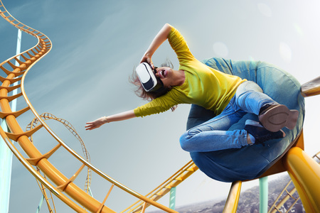 Young woman used Virtual reality helmet VR. She see Roller-coaster parkの写真素材