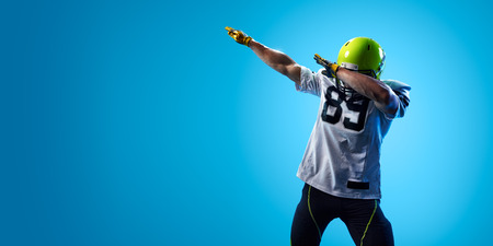 American football sportsman player on blue gradient background. Sport advertisingの写真素材