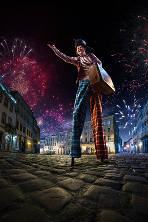 Night street circus performance whit clown. Festival city background. fireworks and Celebration atmosphere.の写真素材