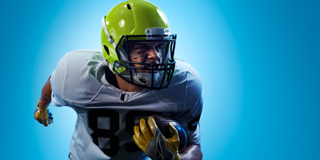 American football sportsman player on blue gradient background. Sport advertisingの写真素材