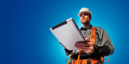 Windmill engineer planing new ecology project. He standing and look in tablet. Color backgroundの写真素材