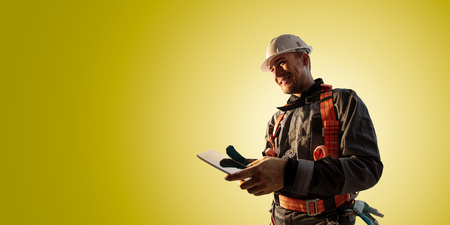 Windmill engineer planing new ecology project. He standing and look in tablet. Color backgroundの写真素材