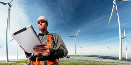 Happy engineer planning new project. He standing a top mount and looking in tablet . around beautiful landscapeの写真素材