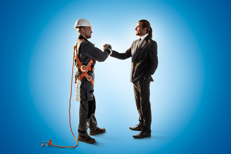 Windmill engineer and businessman shake hands. Color studio backgroundの写真素材