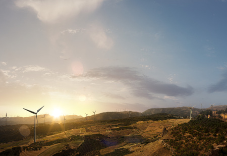 Green energy background Beautiful sunset landscape with windmill forest and fieldの写真素材
