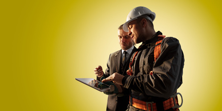 Windmill engineer and businessman planing new ecology project. they standing and looking in tablet. Color backgroundの写真素材