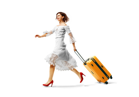 young beautiful woman arrived on vacation.Traveling very happy wallking with suitcase. isolated backgroundの写真素材
