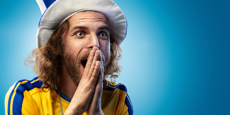 Soccer fan emotion blue background blue and yellow colorsの写真素材