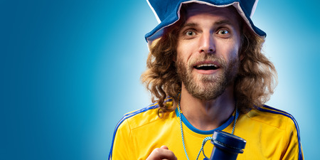 Soccer fan emotion blue background blue and yellow colorsの写真素材