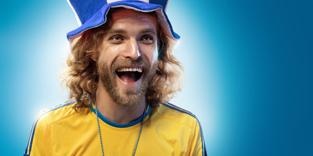 Soccer fan emotion blue background blue and yellow colorsの写真素材
