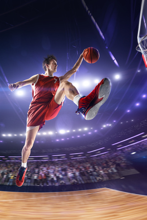 Basketball player in jump. around Arena with blue light spotの写真素材