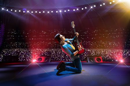 Rock star celebrity on the main stage big music festival. Aroun full stadium of spectators. fans are holding flashlightsの写真素材