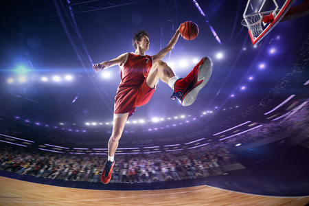 Basketball player in jump. around Arena with blue light spotの写真素材