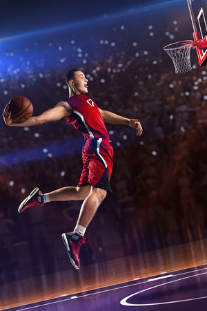 Basketball player in jump. around Arena with blue light spotの写真素材