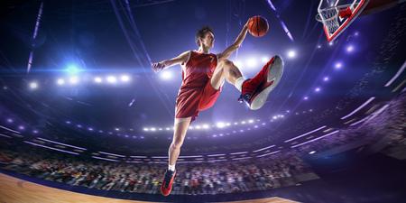 Basketball player in jump. around Arena with blue light spotの写真素材
