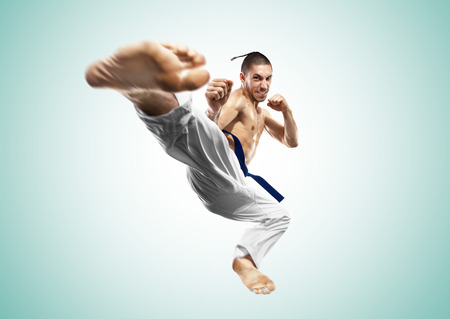 Karate fighter in action isolated gray backgroundの写真素材
