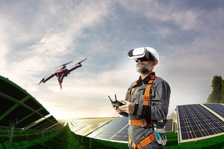 Happy engineer using drone and vr helmet for cheking solar station.
