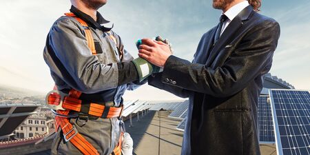 engineer and businessman shake hands. Around wind solar station and landscapeの写真素材