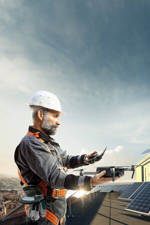 Happy engineer using drone for cheking solar station. in roofの写真素材