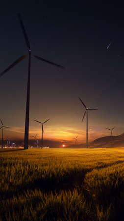 Beautiful sunset field with wind mill generators. big city in backgroundの写真素材